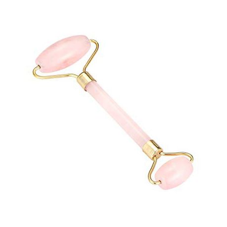 Pink and gold facial roller on a white background