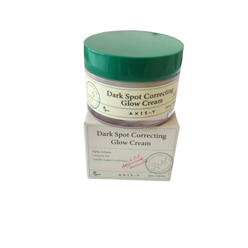 Dark spot correcting glow cream jar with green lid and matching box on a white background